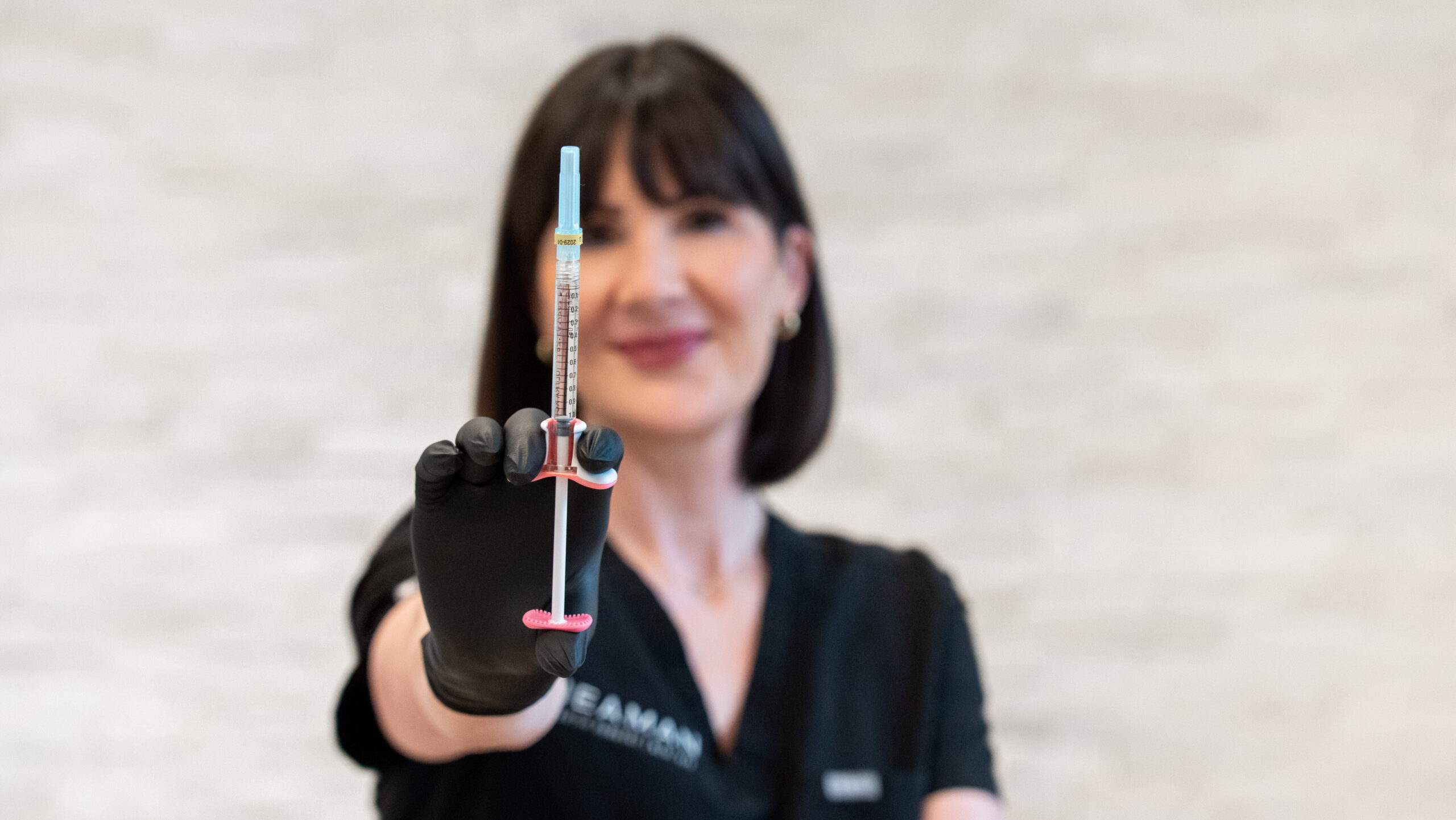 nurse injector holding dermal filler syringe